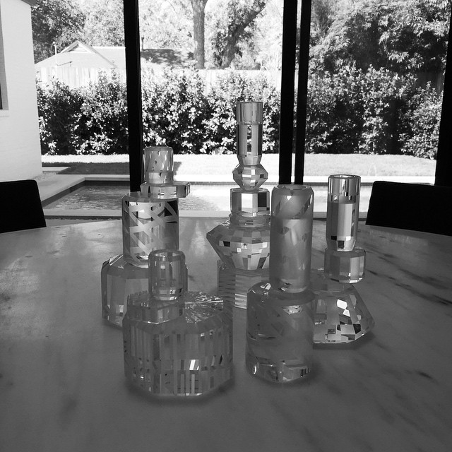 Gaia Gino candle holders on a marble dining table overlooking the pool.