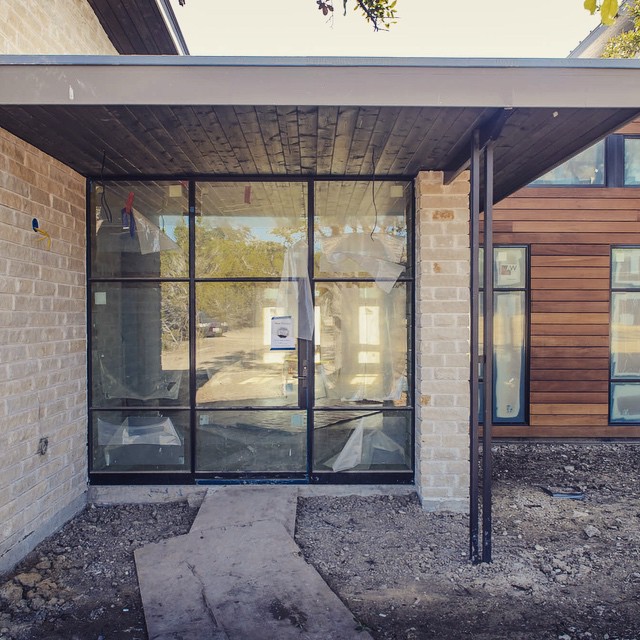 Custom steel entry door with Garapa siding. Foursquare Builders design/build custom home.