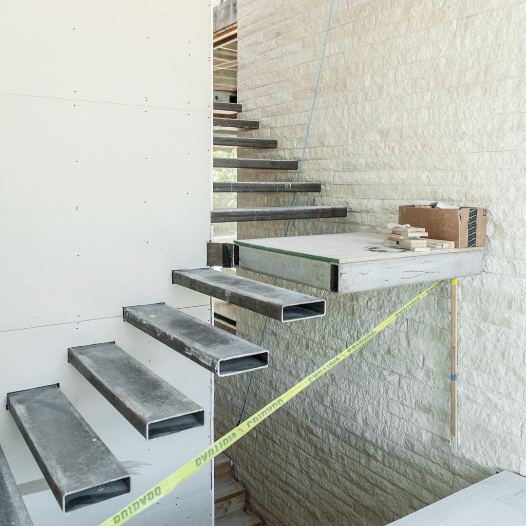 Steel and Stone make up the foundation for a 4 story staircase. Built by @foursquarebuilders designed by photo by @redpantsstudio