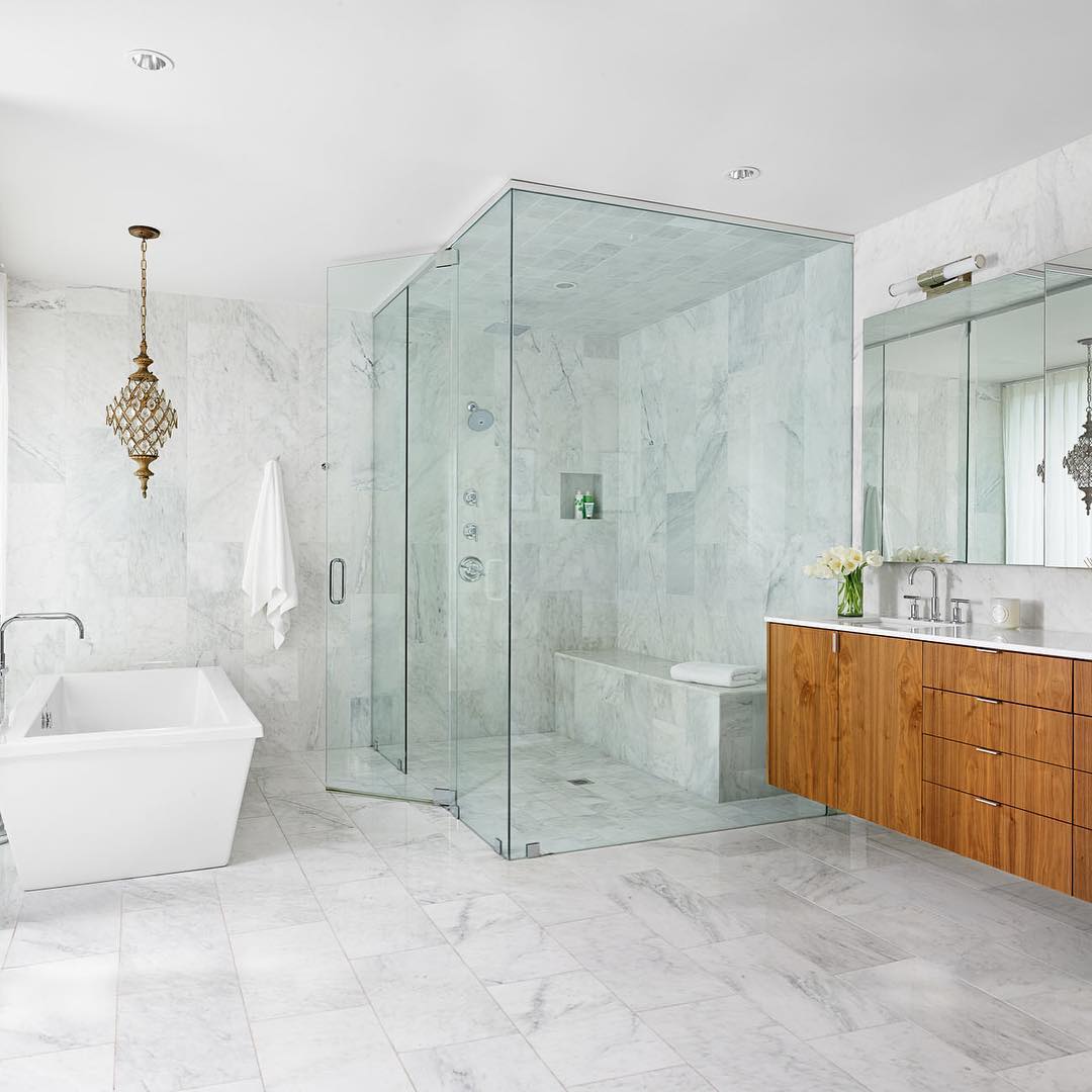 Marble on marble with a splash of walnut make for a spa like bathing experience. Built by @foursquarebuilders