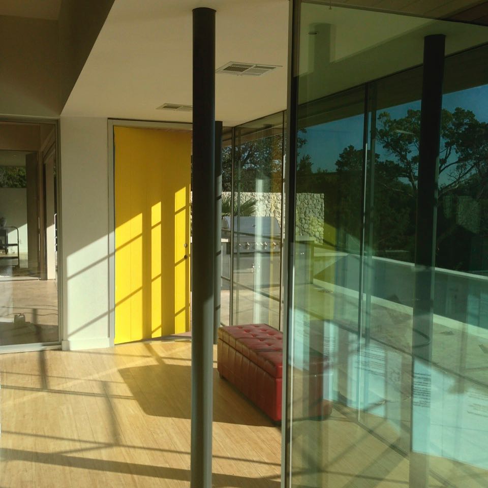 Yellow front door by @webberstudio Walls of glass by @foursquarebuilders