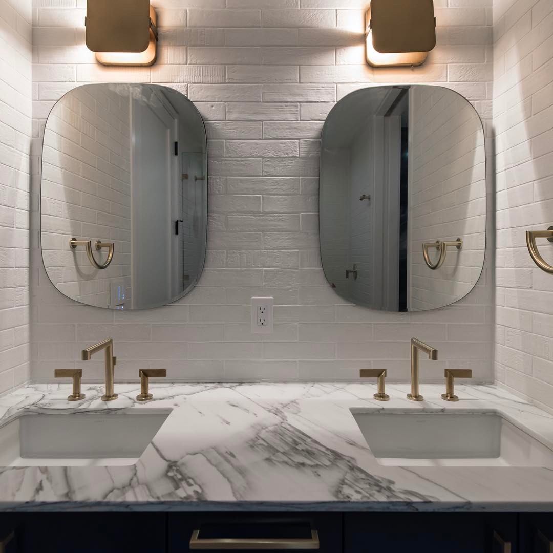 Newport brushed brass faucets against Emil Ceramica tile walls. Designed by @slicdesign Built by @foursquarebuilders Photo by @redpantsstudio