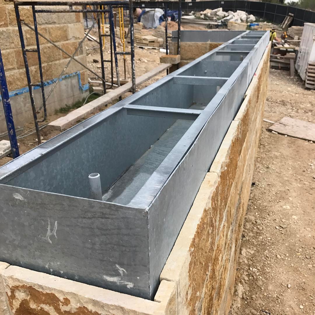 Galvanized steel planters to be hidden in stone wall. Built by @foursquarebuilders