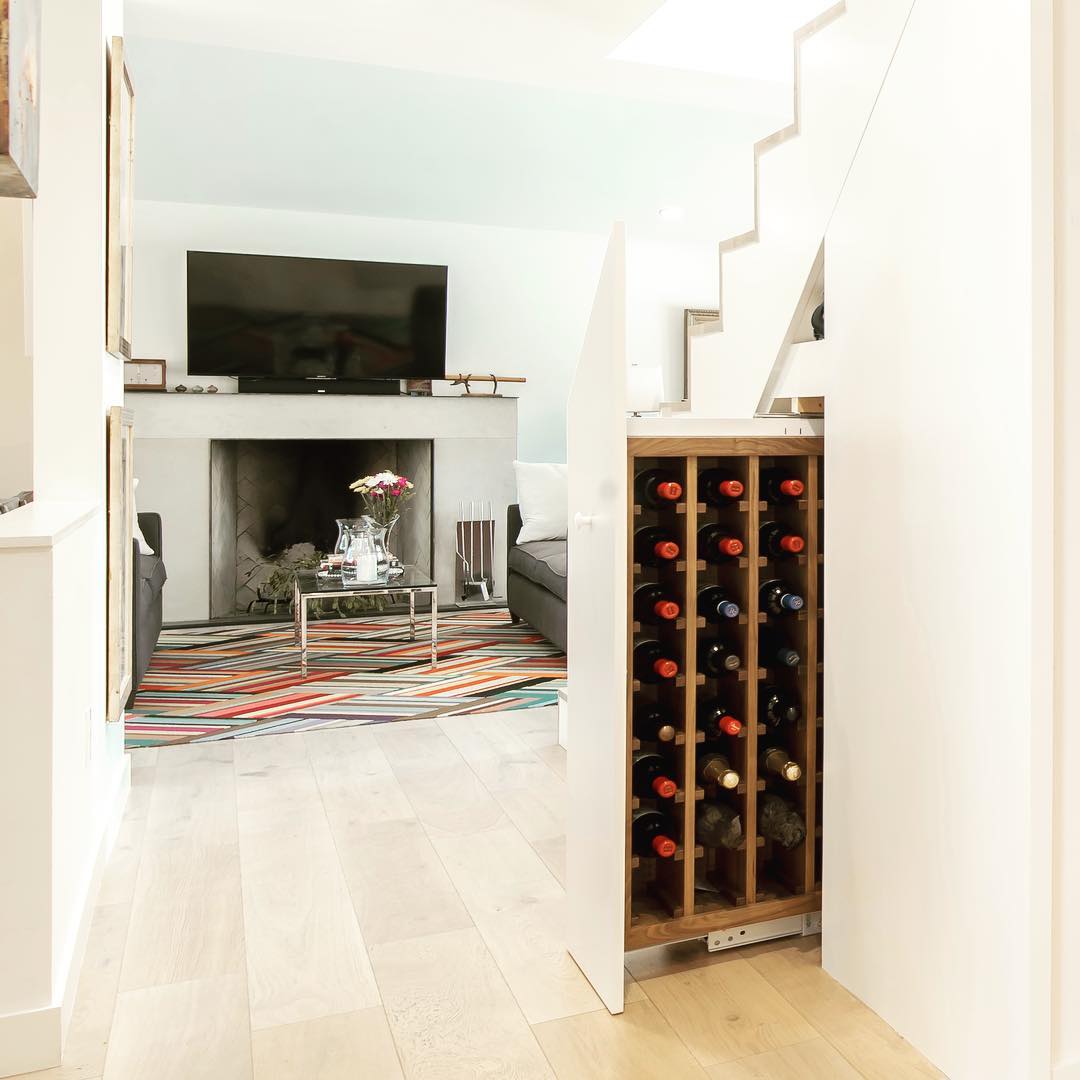 Custom Walnut storage for 64 bottle of wine. Great use of under stair space. Designed & Built by @foursquarebuilders Photo by @redpantsstudio