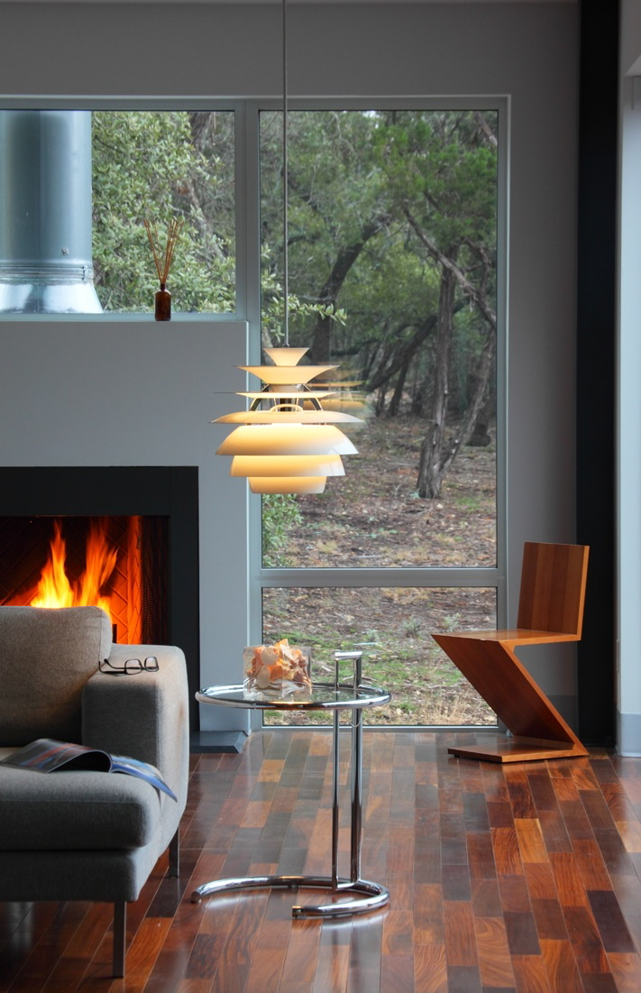 Floating fireplace surrounded by glass with views to its natural environment.