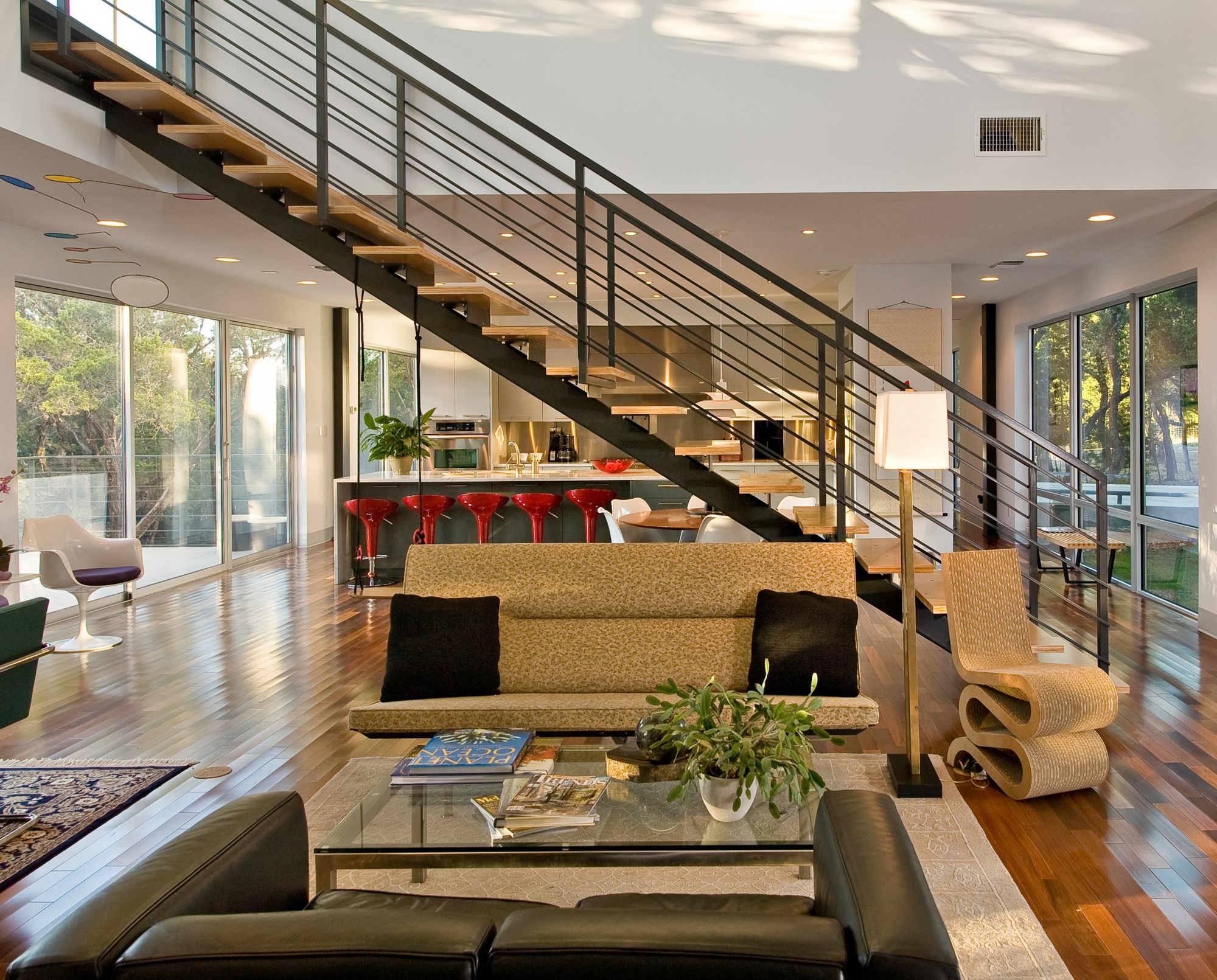 Living, dining, and kitchen are bisected with a floating steel stair system.