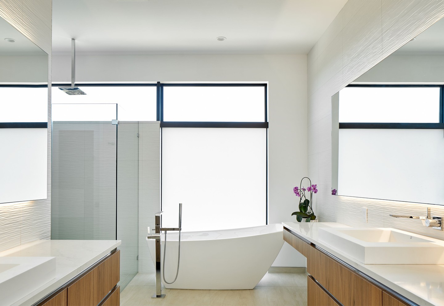 Every detail in this primary bath reflects thoughtful design for a busy family. Frameless glass, sleek fixtures, and ample natural light create a serene, functional retreat that complements the home’s focus on active living.

Architect: @lankerani_architecture